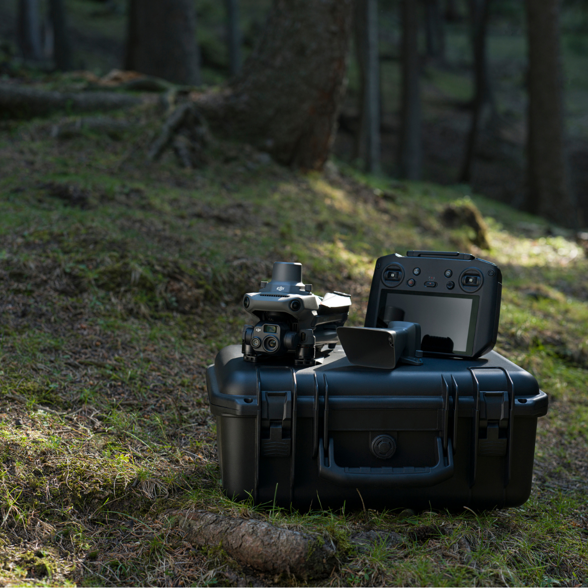 Auf dem Foto ist eine Mavic 3 Enterprise Thermal zu sehen. Die Drohne ist zusammengeklappt und steht auf dem Transportkoffer auf dem Waldboden.