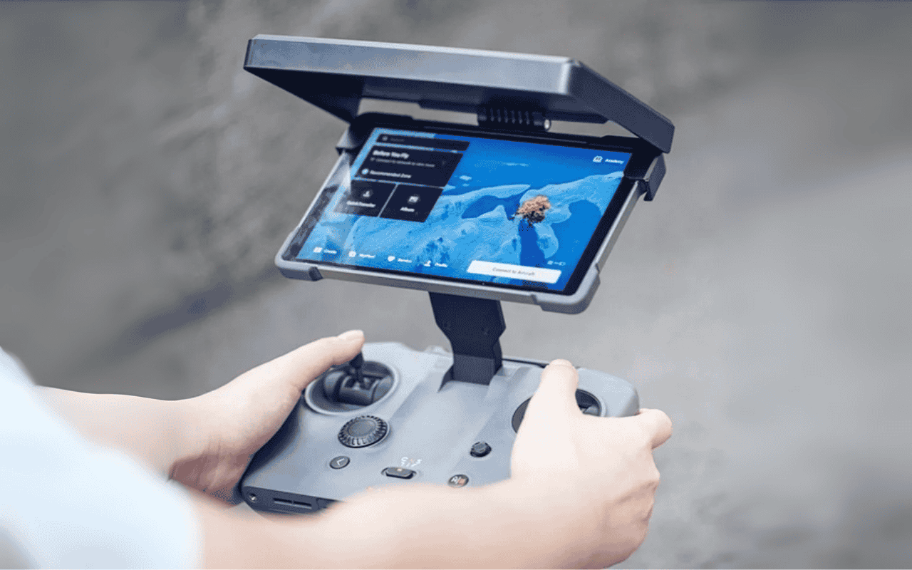 Auf dem Bild hält eine Person den DJI RC Pro 2 Controller, ausgestattet mit einer Sonnenblende, in der Hand.